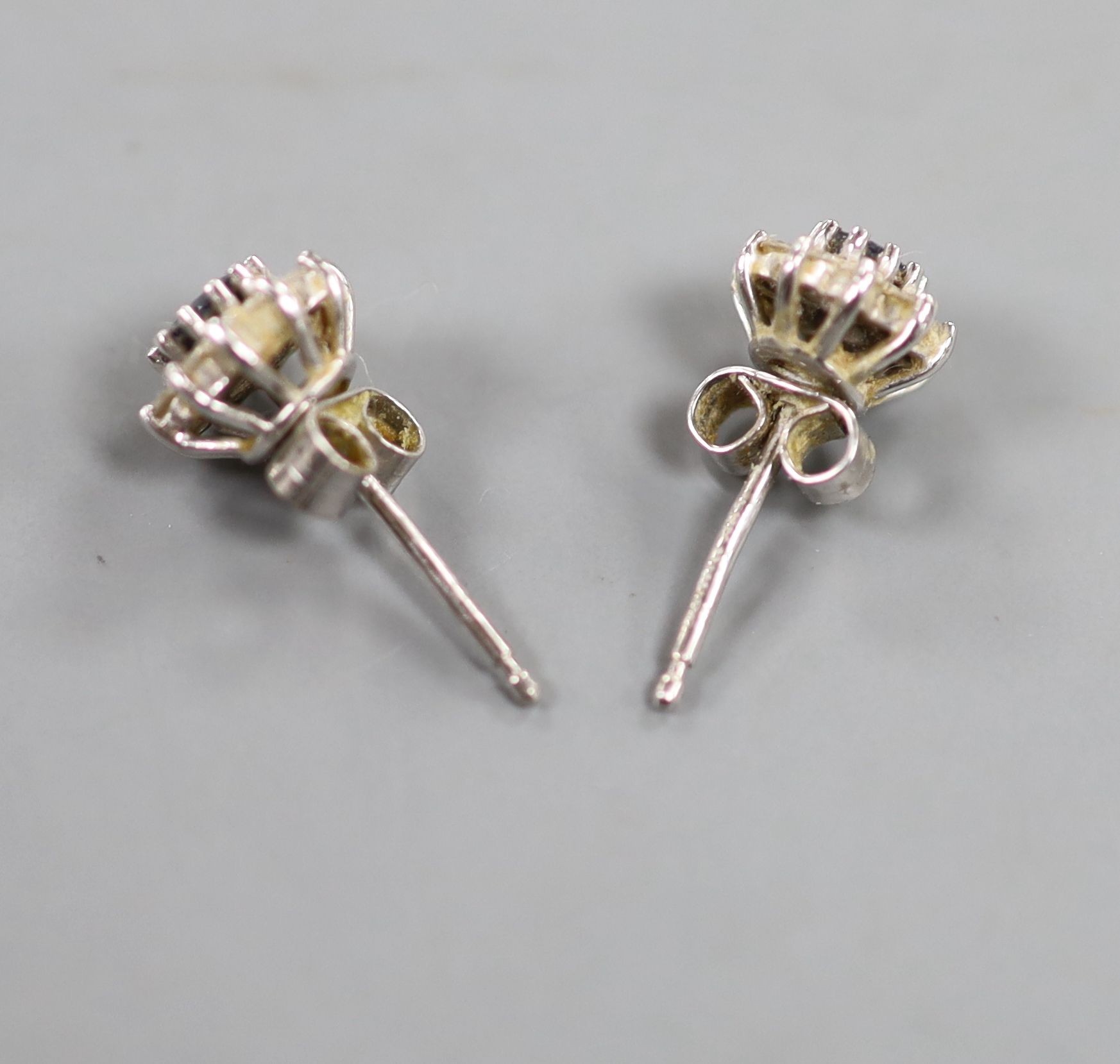 A small modern pair of 18ct white gold, sapphire and diamond cluster set ear studs, 7mm, gross weight 2.5 grams.